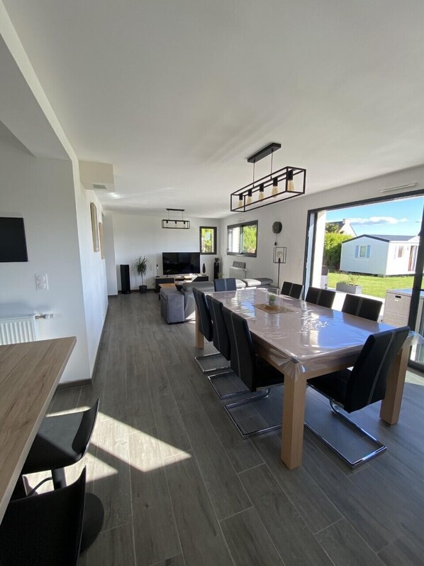 Una cocina moderna con una mesa de comedor grande, electrodomésticos integrados y vistas al exterior.