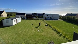 A residential area with a grassy lawn, a person walking a dog, and several mobile homes.