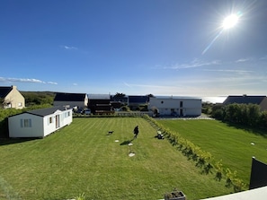 A residential area with a grassy lawn, a person walking a dog, and several mobile homes. - Maison Neuve à 250 Mètres de la Plage (Telgruc-sur-Mer)