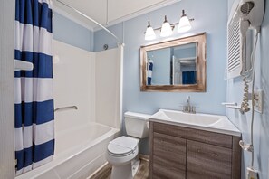 A bathroom with a bathtub, toilet, and sink.