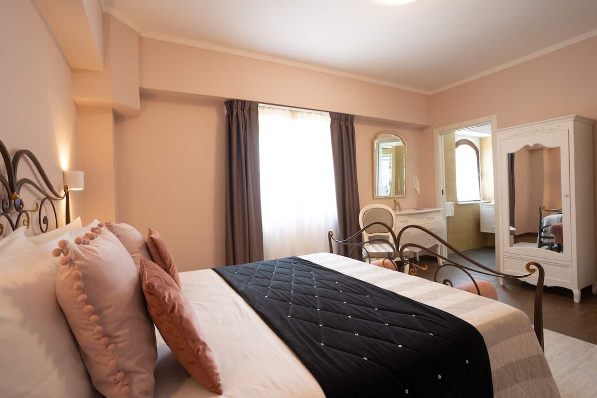 Une chambre à coucher avec un lit, une commode, une chaise et un miroir.