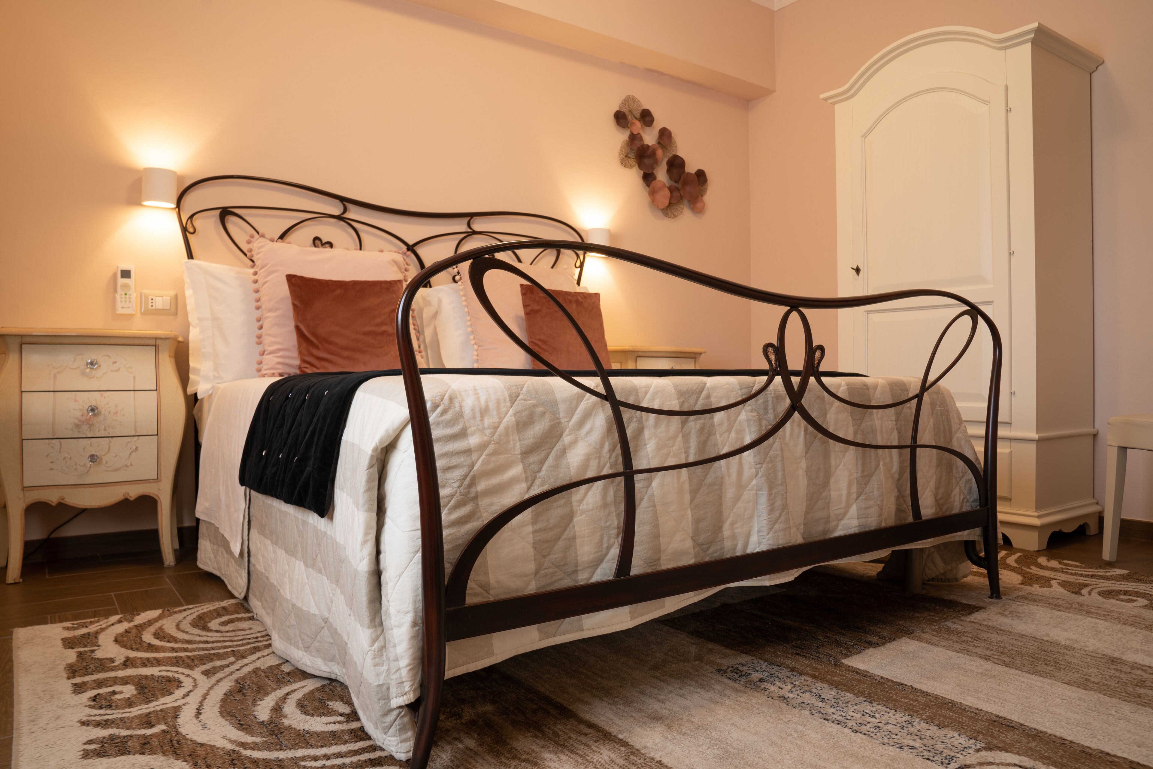 A neatly arranged bedroom with a bed, bedside table, and a wardrobe.