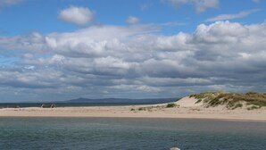 Une plage avec des dunes de sable et un ciel dégagé.