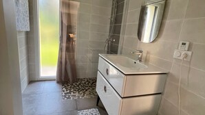 Un bagno con doccia, toilette, lavandino e specchio.