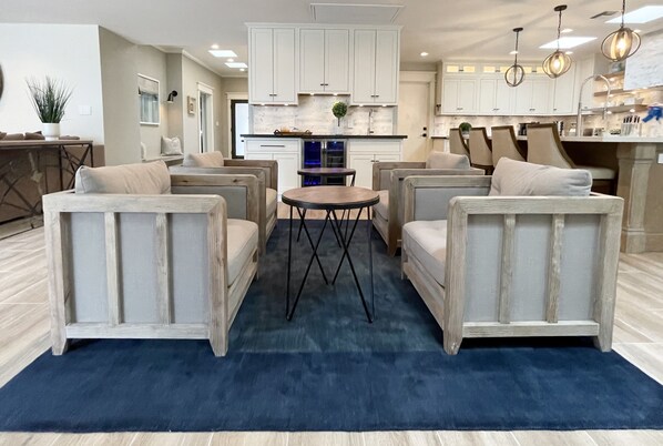 A modern kitchen with white cabinets, a central island, and pendant lighting. - Luxurious Property with Dual Master Suites in McCormick Ranch (Scottsdale)