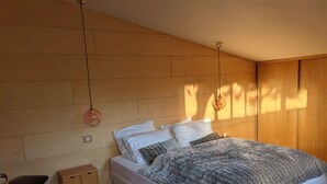 Ett modernt sovrum med en säng, sängbord och en stol.
