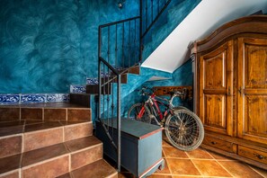 Staircase leads to a landing with a unique textured wall and a classic cabinet.