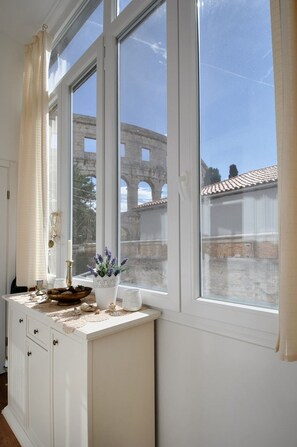 Una habitación con un amplio ventanal que da a una antigua construcción de piedra.
