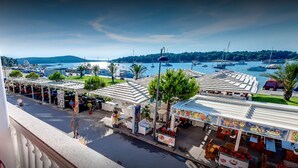 A coastal town with outdoor seating areas, a marina with boats, and a clear view of the sea. - Lovely Sea View Apartment - Belvi C1 (Medulin)