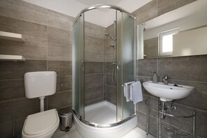 Bathtub, hair dryer, towels, toilet paper