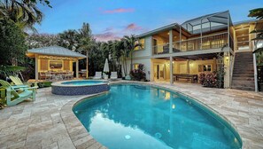 Uma casa moderna com piscina, área de estar externa e varanda coberta.