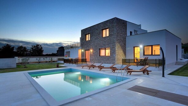 A modern two-story house with a swimming pool, outdoor seating, and a well-lit entrance. - Villa Gigetto with Private Pool and Big Garden (Medulin)