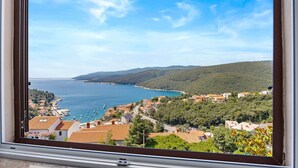 A coastal town with buildings, a sea view, and hills in the background. - Lady M Gold - Balcony and Sea View (Rabac)