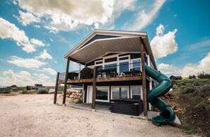A two-story house with a balcony and a slide. - Ultimate Bear Lake Getaway! Large Deck w/ Slide! Paddleboards & Kayaks! (Garden City)