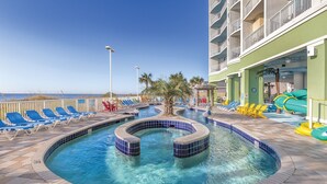 Un espace piscine doté d’un jacuzzi circulaire, de chaises longues et offrant une vue sur l’océan.