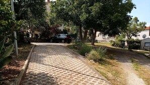 Une allée pavée mène à une maison où une voiture est garée à proximité.