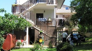 A two-story building with a balcony, a garden, and a pathway leading to the entrance. - Istriensonne 0043 - Lucano-3 with a  large garden, two balconys, 2 air conditions and parking lot (Medulin)
