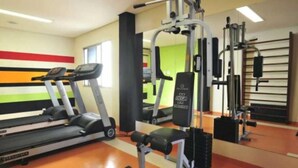 A gym with treadmills, weight machines, and a bench. - Veneza Palace Hotel (Cuiabá)