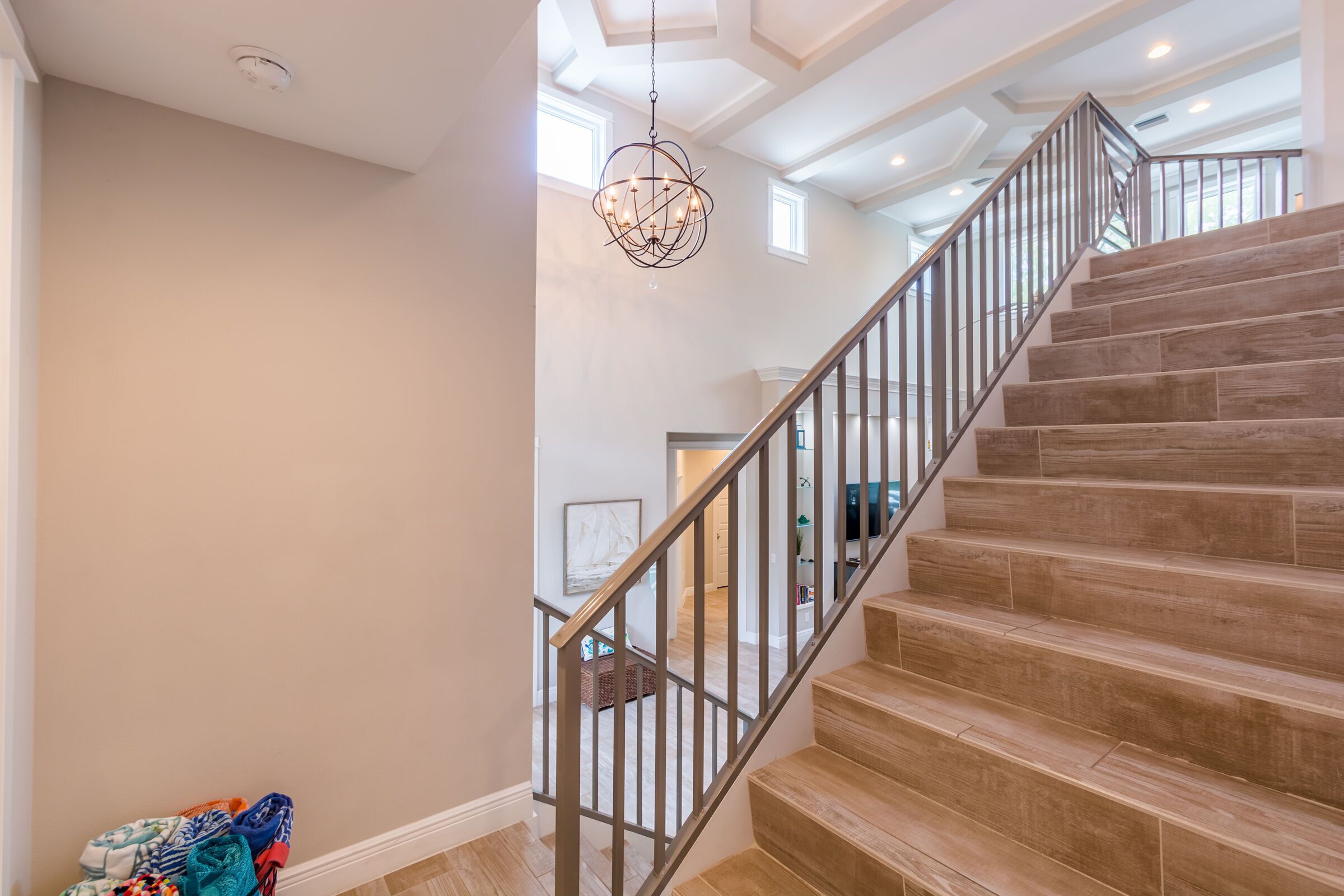 Una escalera de madera con barandillas metálicas que lleva a un piso superior.
