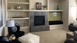 A living room with a fireplace, TV, and various decorative items on shelves. - Beautiful Grayhawk Condo!  Negotiated rates and FLEXIBLE Dates-contact owner (Scottsdale)