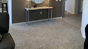 A living room with a large round mirror, two wall-mounted lamps, a console table with a small plant, and a carpeted floor. - Beautiful Grayhawk Condo!  Negotiated rates and FLEXIBLE Dates-contact owner (Scottsdale)