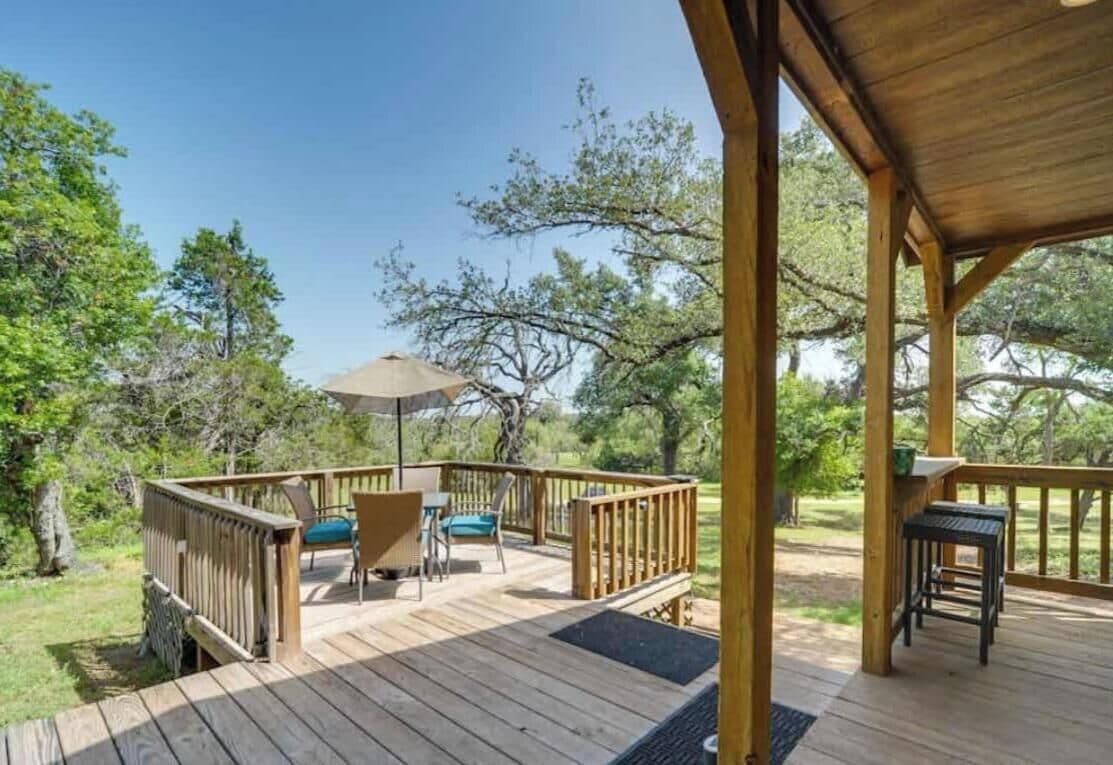 A wooden deck with outdoor seating and a covered area.