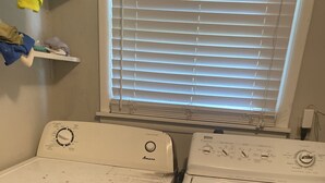 Two front-loading washing machines in a laundry room with a window above them. - A great peaceful apartment (Mississippi Biloxi)