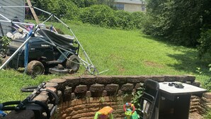 A backyard with a brick structure, a lawn, and a vehicle. - A great peaceful apartment (Mississippi Biloxi)