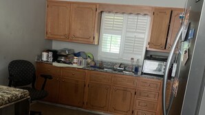 A kitchen with wooden cabinets, a built-in oven, and a refrigerator. - A great peaceful apartment (Mississippi Biloxi)