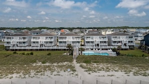 A beachfront hotel with multiple-story buildings, a swimming pool, and a sandy beach area. - "Waters Edge 427-D" - Oceanfront Condo w/ Community Pool, 2 Bedrooms / 2 Bathrooms (Holden Beach)