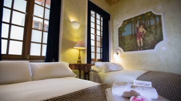 A hotel room with two beds, a painting on the wall, and a note on the bed.