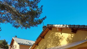 An outdoor patio with sun loungers, a table, and a covered area with a pergola. - CHALET 126 M² in PRALOUP (Uvernet-Fours)