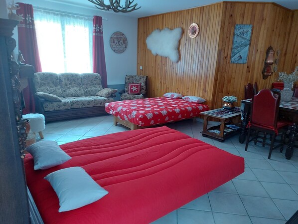 A room with a large bed, a sofa, a dining table, and a chair. - CHALET 126 M² in PRALOUP (Uvernet-Fours)