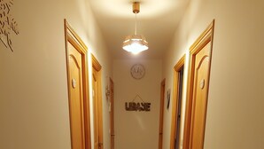 A hallway with wooden doors, a tiled floor, and a ceiling light fixture.