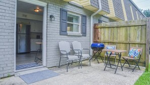 Ein Wohnhaus mit Garage, einer kleinen Terrasse mit zwei Stühlen und einem Tisch sowie einem Holzzaun.