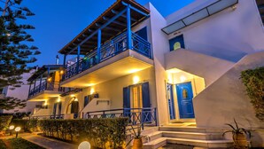 A two-story building with a balcony, a blue door, and a staircase leading to the entrance. - Sand Garden Apart, Wi‑Fi & garden near the beach (Agios Dimitrios)