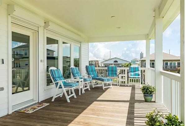 Relax in a serene outdoor space with lounge chairs and a potted plant, surrounded by views of the neighborhood.