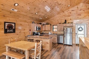 Cozy cabin-style kitchen with a central island, oven, and wooden cabinets.