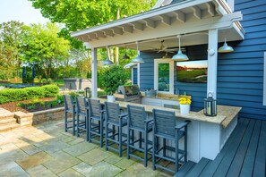 An outdoor bar area with a grill, bar stools, and a pergola with hanging lights. - 7 Bedroom Country Estate with Large Private Pool! (Sawyer)