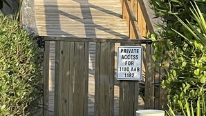 Una puerta de madera con un letrero que indica acceso privado para las unidades 1180 A&B 1182.