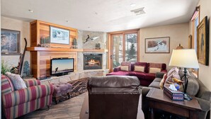 A cozy living room with a fireplace, a television, and comfortable seating.