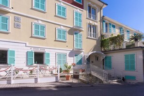 Un edificio de varios pisos con balcones, una escalera y un letrero que indica un restaurante.