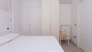A bedroom with a bed, a wardrobe, a radiator, and a chair. - N236 Numana, two-room apartment with sea view in the heart of the town (Numana)