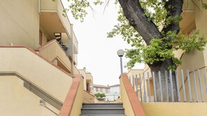 A staircase leading up to a building with a tree on the right. - M285 - Marcelli, comfortable three-room apartment with terrace (Marcelli)