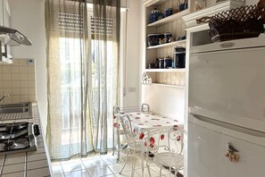 Kjøleskap, ovn, oppvaskmaskin og spisebord