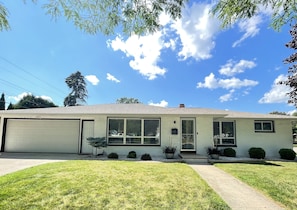A single-story house with a garage, a front porch, and a well-maintained lawn. - 🏈 Minutes from Lambeau • 5 bdrms • Heated Garage • Home Theatre • Game Room (Green Bay)