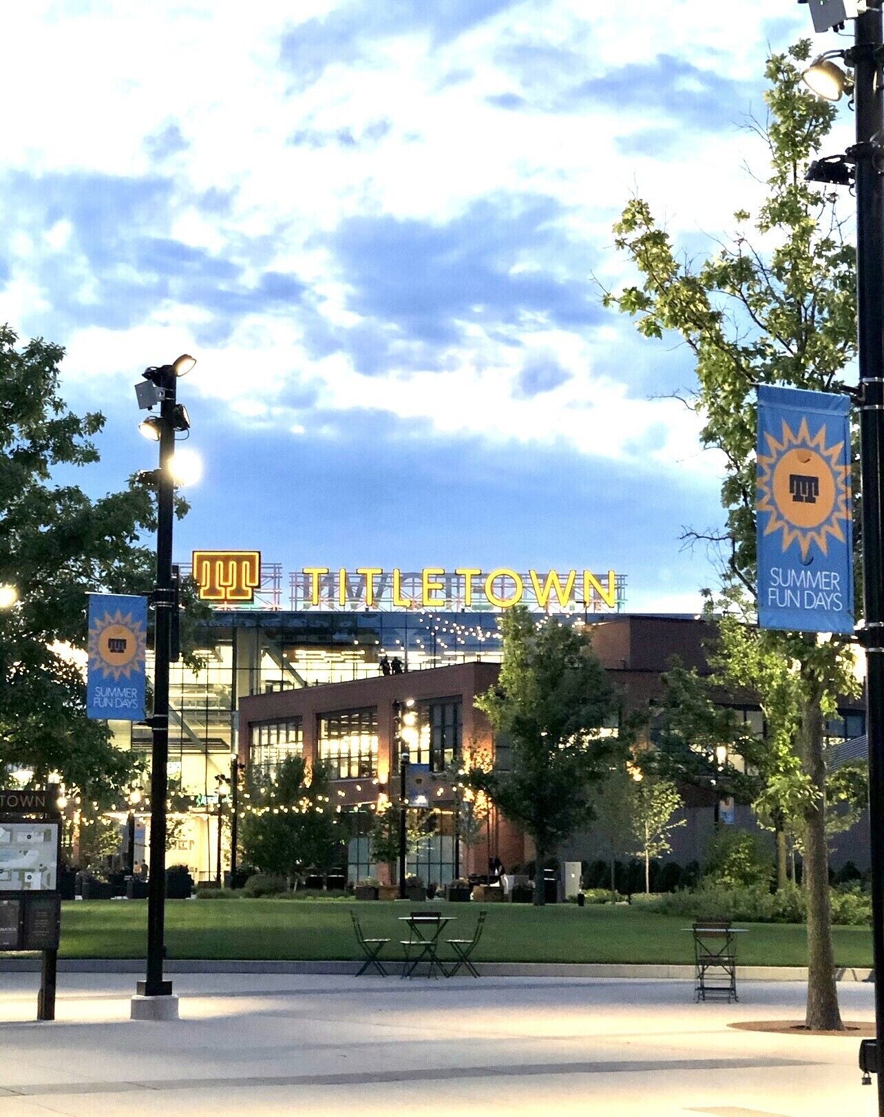 Un edificio con un letrero que dice "TITLE TOWN" y pancartas anunciando "SUMMER FUN DAYS".