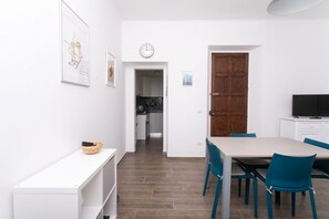 Una cocina moderna con armarios blancos, una puerta de madera y un reloj en la pared.