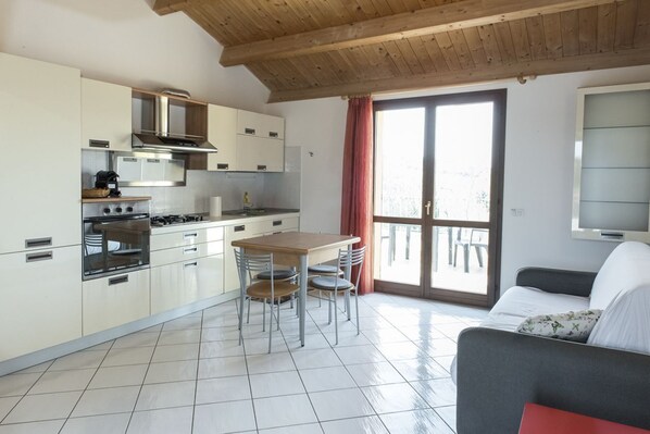 Una cocina moderna con comedor, sofá y televisor.