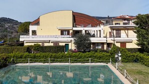 A hotel with a pool, a curved roof, and a garden. - N036 - Numana, two-room apartment with terrace in residence with swimming pool (Maratta)